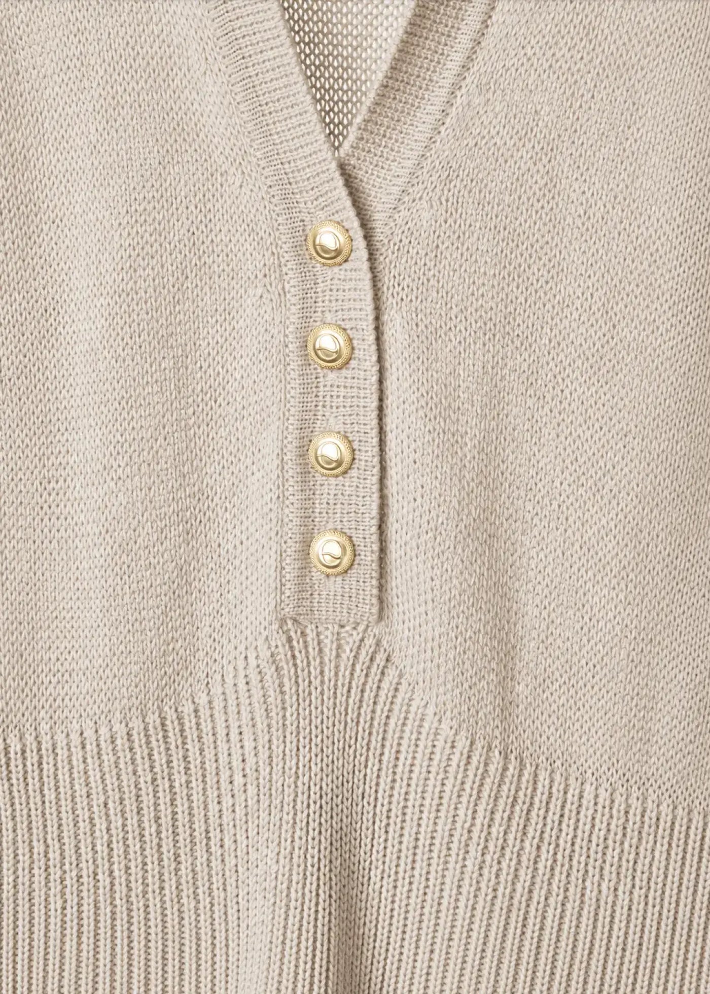 Close-up detail of a luxury fine cotton knit dress featuring a refined V-neckline, signature gold-tone buttons, smooth jersey-knit construction, and elegant tailoring that highlights exceptional craftsmanship.