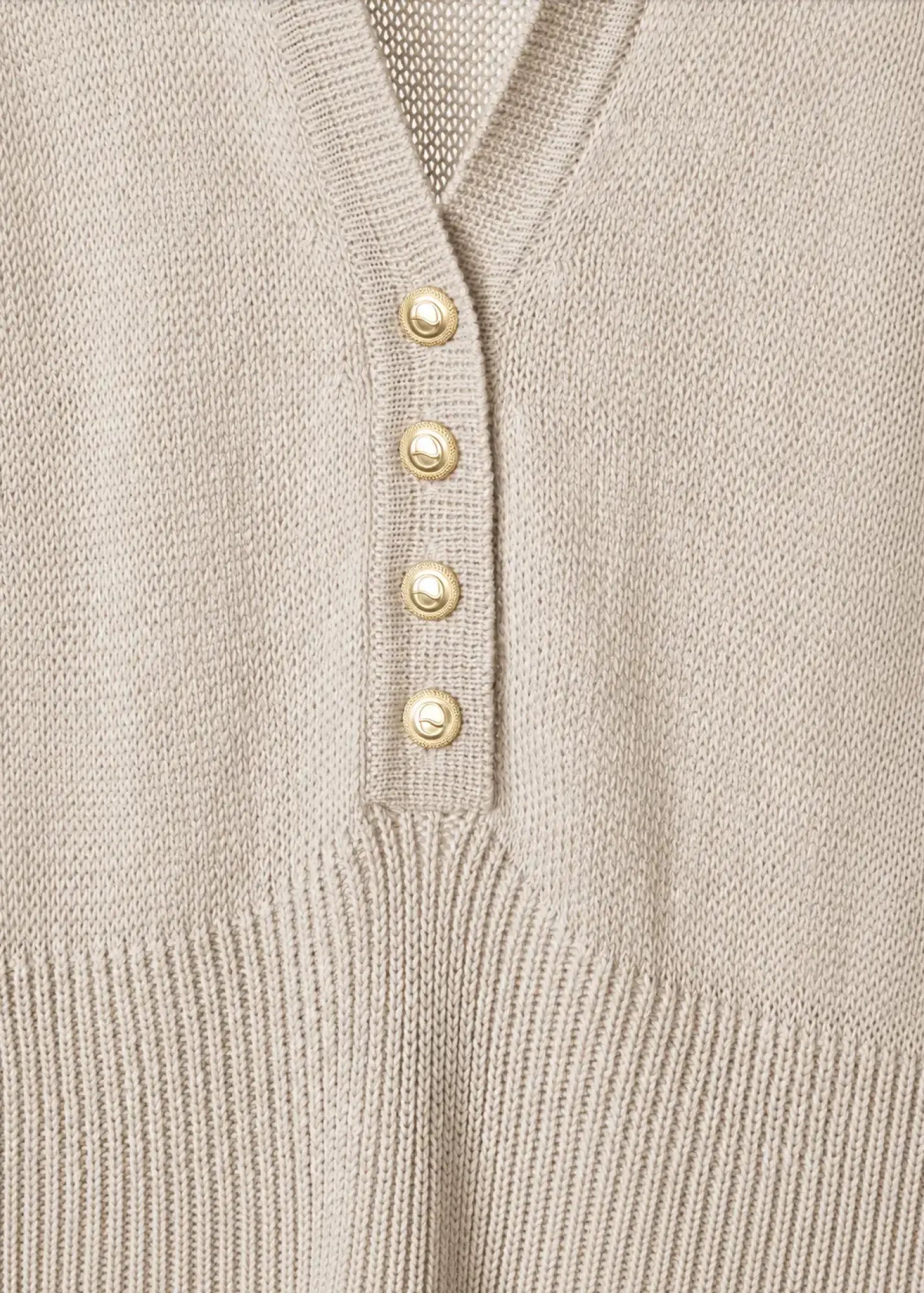 Close-up detail of a luxury fine cotton knit dress featuring a refined V-neckline, signature gold-tone buttons, smooth jersey-knit construction, and elegant tailoring that highlights exceptional craftsmanship.